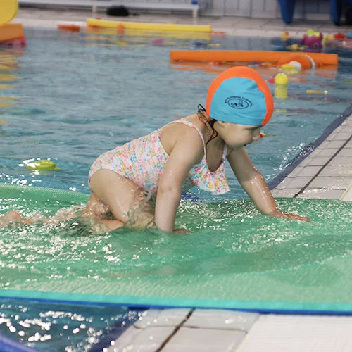 bébé nageur sur un tapis épais dans le bassin